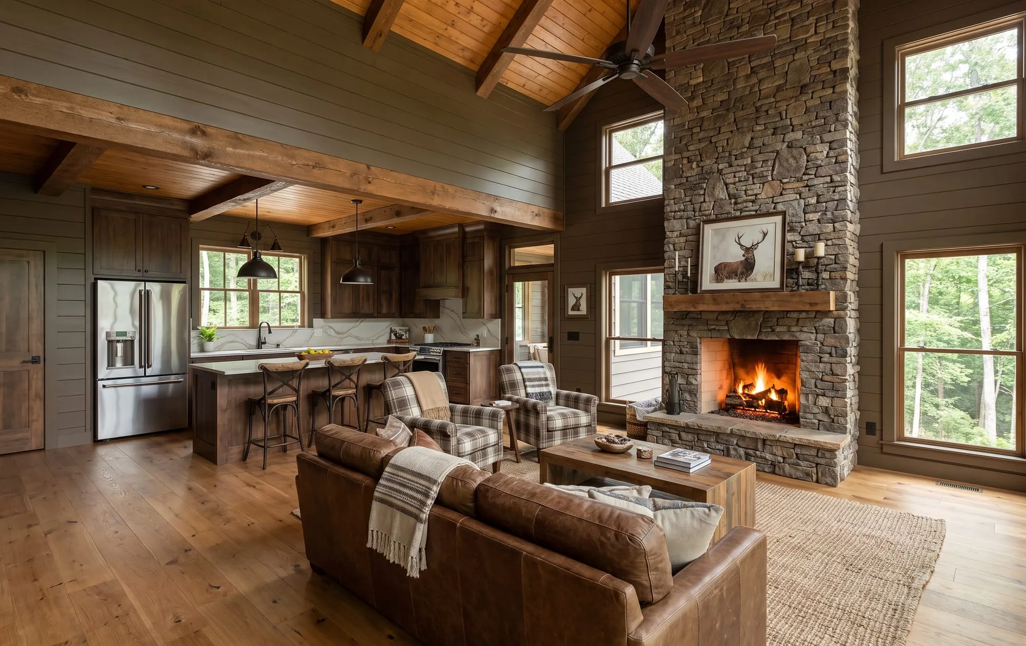 The Tesnatee — living room and kitchen together under the vault, with a full-height stone hearth and exposed beams